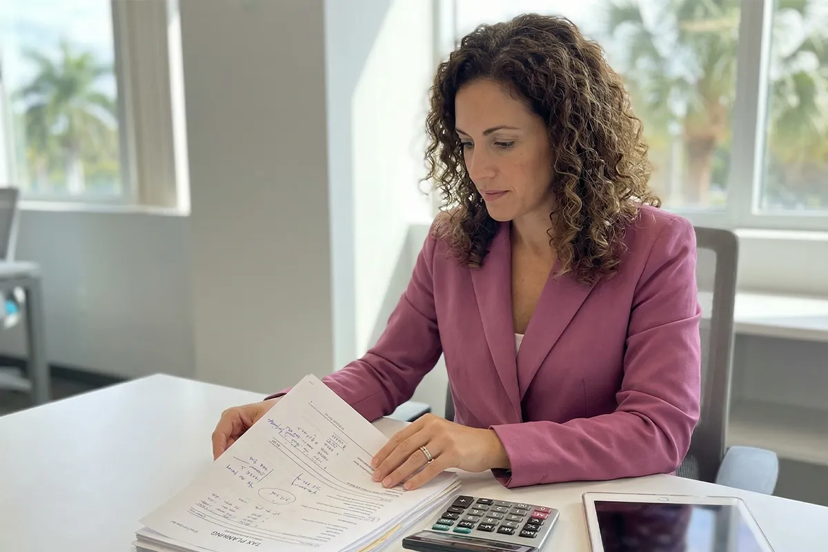 business tax strategist Sarasota, a business owner reviewing tax planning documents with a calculator on the desk