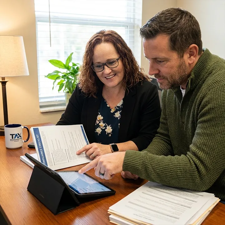 business tax strategist Sarasota, a Tax with Integrity co-owner reviewing a compliance checklist with a business owner client